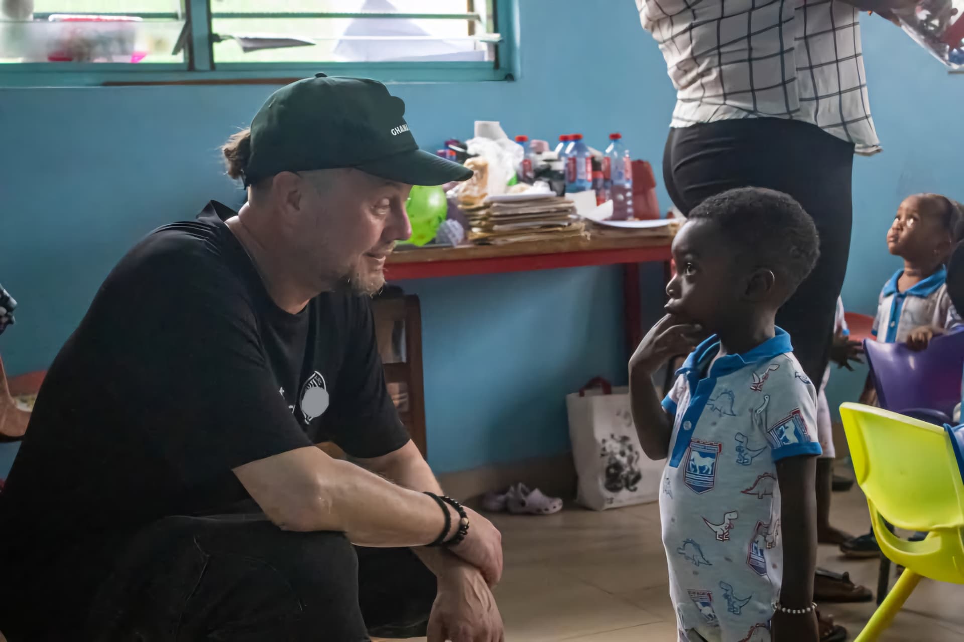 A volunteer talking with a young child in a classroom