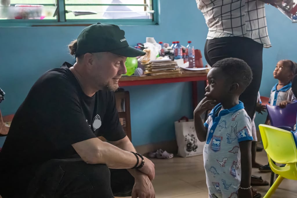A volunteer talking with a young child in a classroom