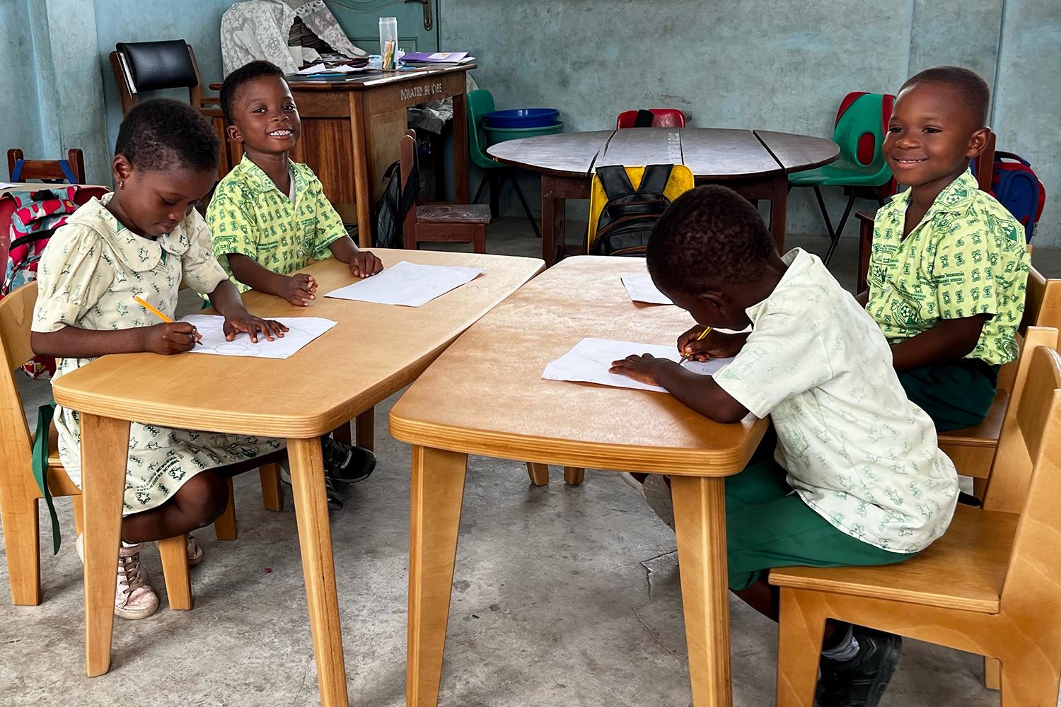 Children drawing together at their school desks in Ghana